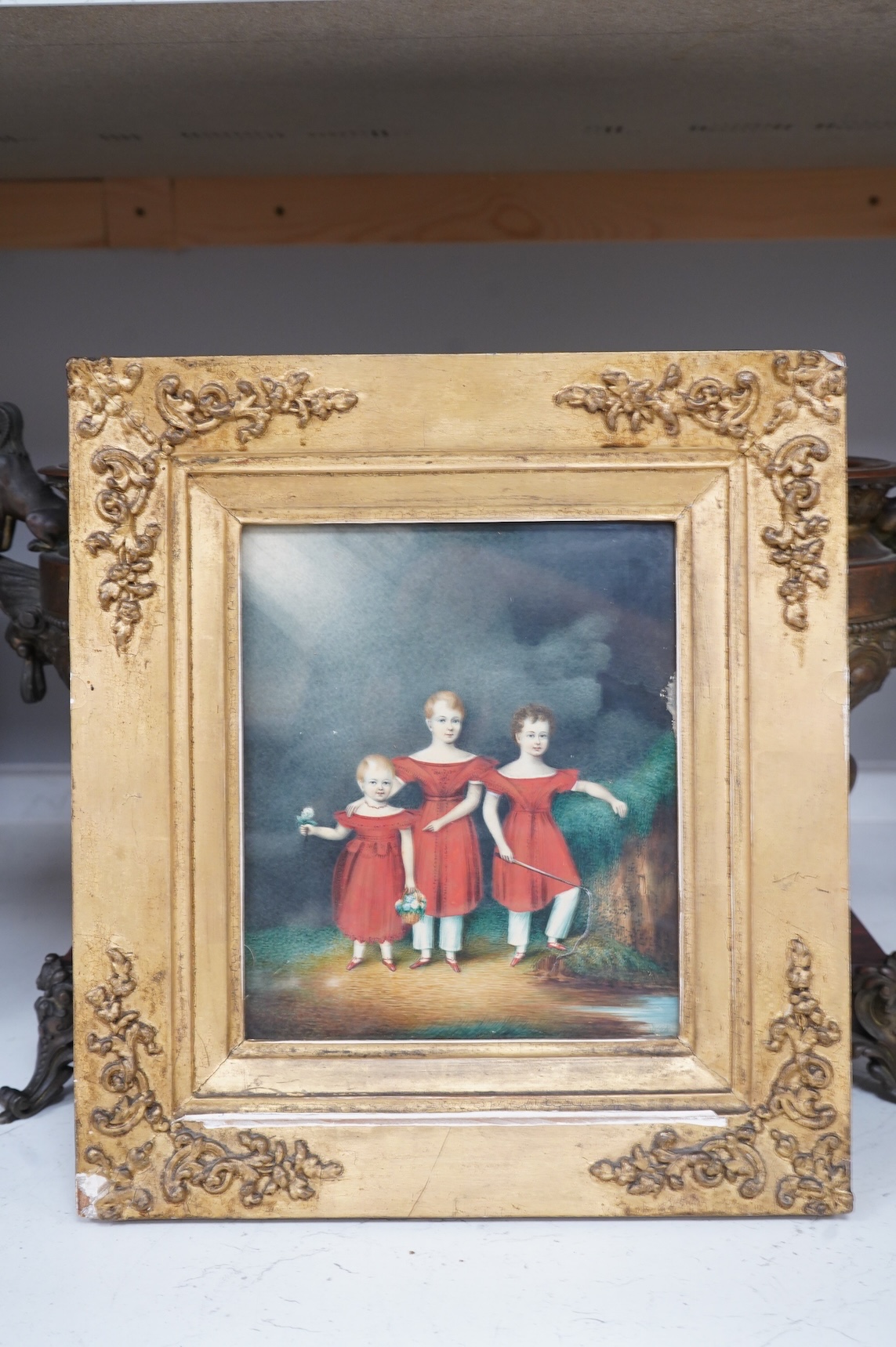 Regency School, Portrait of three siblings beside a river, unsigned, watercolour on card, 20 x 17cm, ornate gilt frame